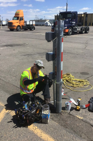 electrician repairing a truck charging station on the street